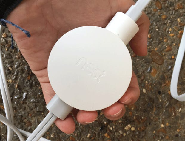 Man holding the Nest power adapter. Man holding the Nest power adapter.