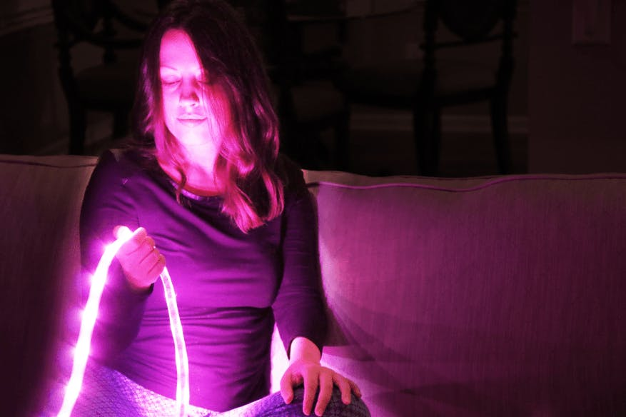 Girl holding Magenta Philips Hue Lightstrip Plus. Girl holding Magenta Philips Hue Lightstrip Plus.
