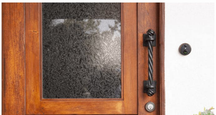 A SkyBell Doorbell Camera installed beside the door outside. A SkyBell Doorbell Camera installed beside the door outside.